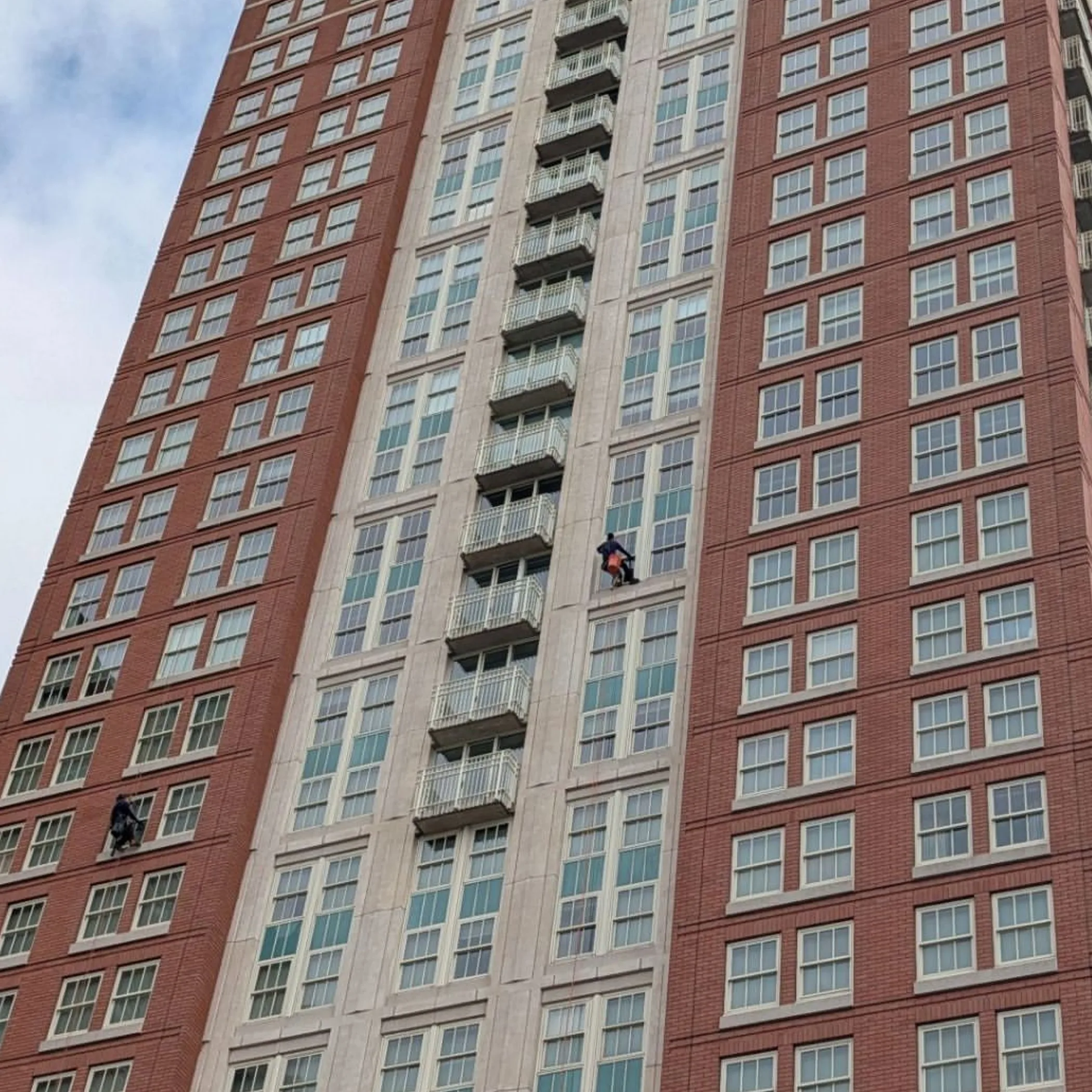 technicians cleaning tall building facade